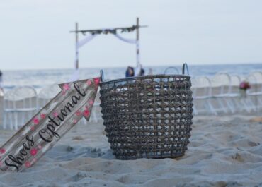 Beach wedding scene with basket and sign